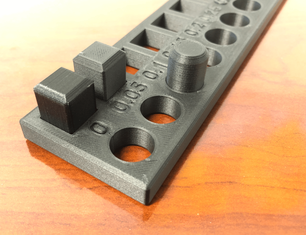 3D printed test part with holes and pins for checking tolerances and clearances
